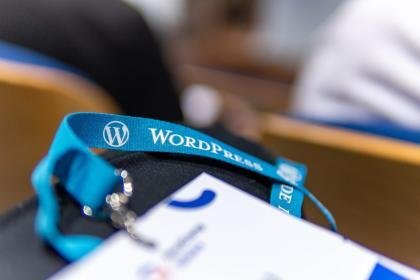 Close-up shot of a lanyard with the WordPress logo during a conference.